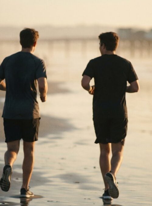 Men walking to a beach workout at sunrise near a San Diego men's sober living home