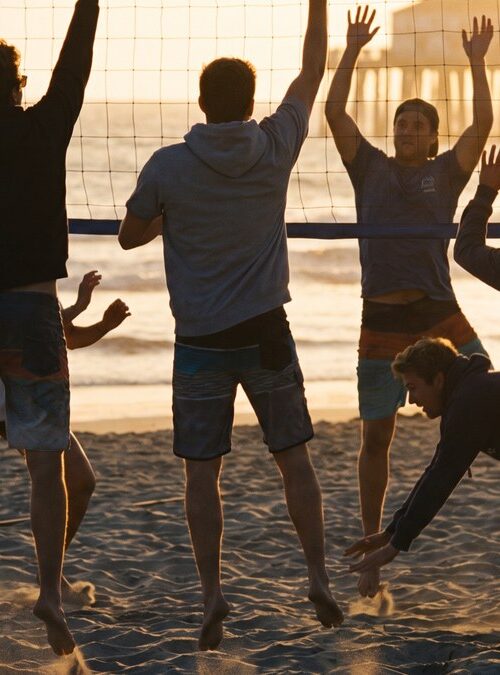 Young adults playing beach volleyball at golden hour near young adult sober living in San Diego