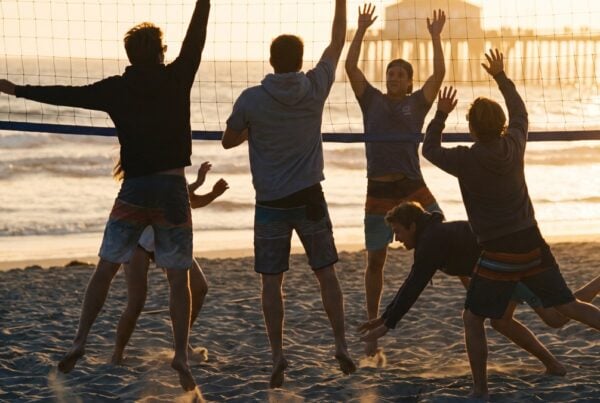 Young adults playing beach volleyball at golden hour near young adult sober living in San Diego